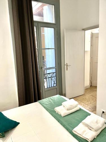 une chambre avec un lit avec deux serviettes dessus dans l'établissement La Canourgue, Appart de charme ,Parking gratuit, à Montpellier