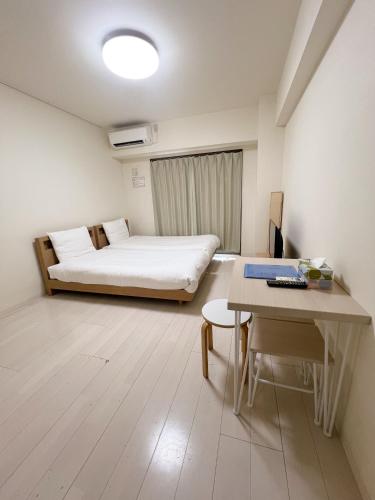 a small room with a bed and a table at CIEL BLEU in Tokyo
