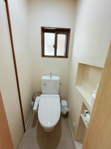 a small bathroom with a toilet and a window at Osaka Castle Park Station, 10 minutes walk to Kyobashi Station, direct access to Shinsaibashi, Umeda, Kansai Airport, Kyoto, Nara, USJ, can accommodate up to 10 people in Wada