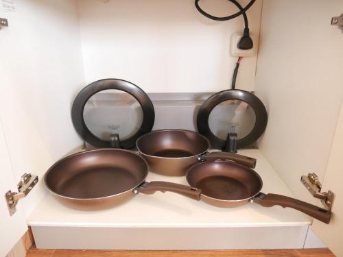 two pans sitting on a counter in a kitchen at Wonder Lodge Niseko in Niseko