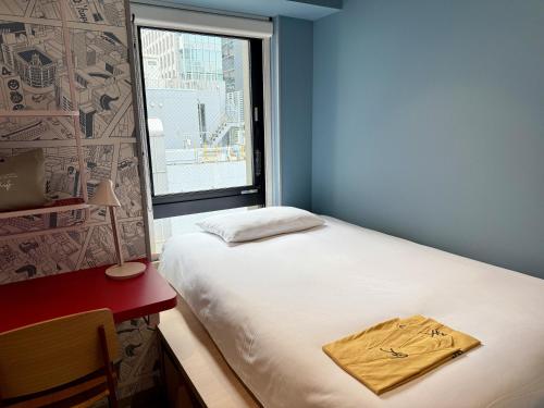 a small bedroom with a bed and a window at lyf Ginza Tokyo in Tokyo