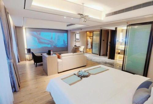 a hotel room with a large bed and a living room at GreenTree Eastern Dali Railway Station Hotel in Dali