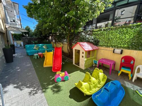 a backyard with a play area with chairs and toys at Hotel De La Ville in Rimini