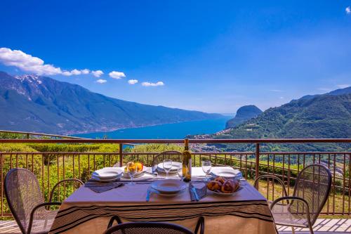 a table on a balcony with a view of the water at Residence Bellevue in Tremosine Sul Garda