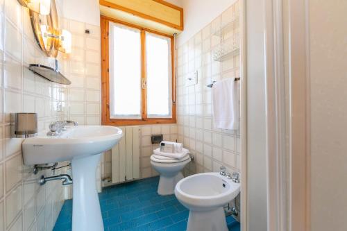 een witte badkamer met een wastafel en een toilet bij Residence Bellevue in Tremosine Sul Garda