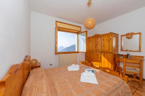 een slaapkamer met een bed, een bureau en een raam bij Residence Bellevue in Tremosine Sul Garda