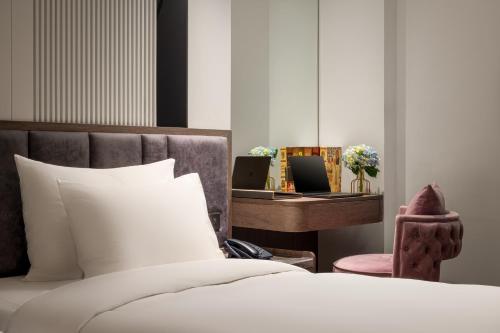 Una cama o camas en una habitación de H Hôtel L'Art Hanoi