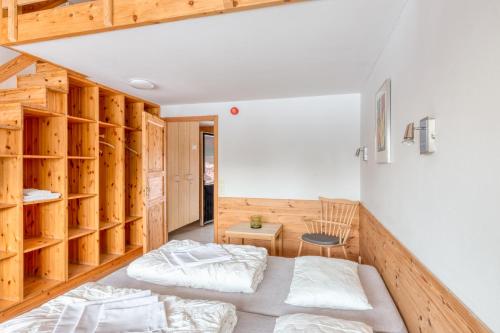 two beds in a room with wooden walls at Kvitåvatn Fjellstue in Gaustablikk