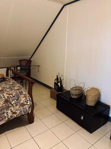 a bedroom with a bed and a table and baskets at La Salazienne in Salazie