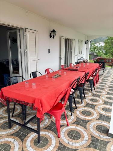 a row of red tables and chairs on a patio at La Salazienne in Salazie
