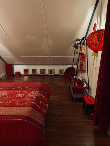 a room with a red bed and a room with pictures at La Salazienne in Salazie