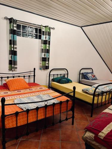 a bedroom with two beds in a room at La Salazienne in Salazie