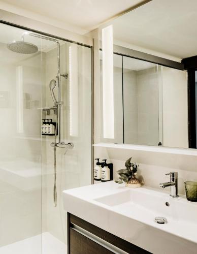 a white bathroom with a sink and a shower at Paradisus Salinas Lanzarote - All Inclusive - Adults Only in Costa Teguise
