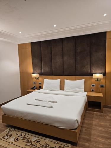a bedroom with a large bed and two lamps at Hotel Shemron 