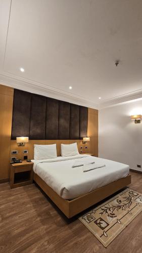 a bedroom with a large bed with a large headboard at Hotel Shemron 