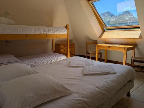 a bedroom with two bunk beds and a window at Auberge de Pra-Loup in Pra-Loup