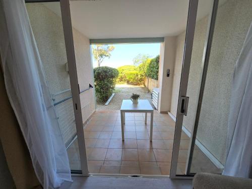 a door leading to a patio with a table at Appartement Cosy, jardin, piscines in Grimaud