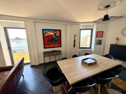 une salle à manger avec une table et des chaises en bois dans l'établissement Bel appartement de 105m2 VUE RIA d'ETEL, à Étel