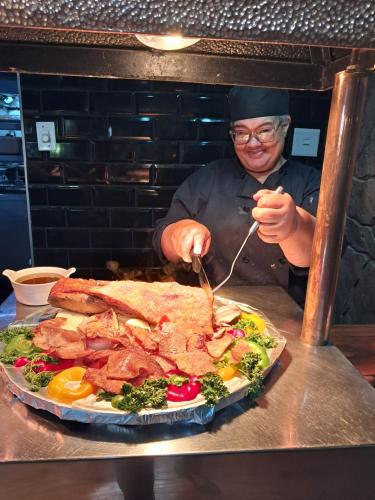 a man is preparing a plate of food on a table at Kalahari Lodge Kimberley in Kimberley
