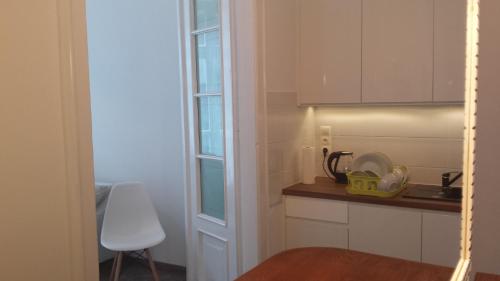 una cocina con armarios blancos y una silla blanca en Apartament Bogusławskiego en Cracovia