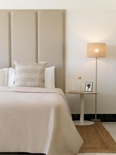 a bedroom with a white bed and a side table at Paradisus Salinas Lanzarote - All Inclusive - Adults Only in Costa Teguise
