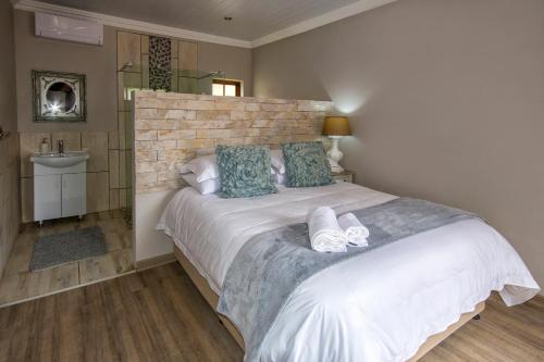 sypialnia z dużym białym łóżkiem z niebieskimi poduszkami w obiekcie Sewende Hemel w mieście Kroonstad