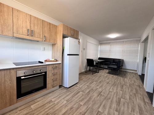 a kitchen with a refrigerator and a table with chairs at Spacious 4-Bedroom Home in Belgian Gardens in Belgian Gardens