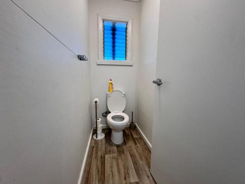 a small bathroom with a toilet with a window at Spacious 4-Bedroom Home in Belgian Gardens in Belgian Gardens