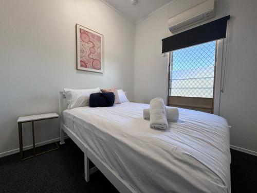 a bedroom with a large white bed with a window at Spacious 4-Bedroom Home in Belgian Gardens in Belgian Gardens