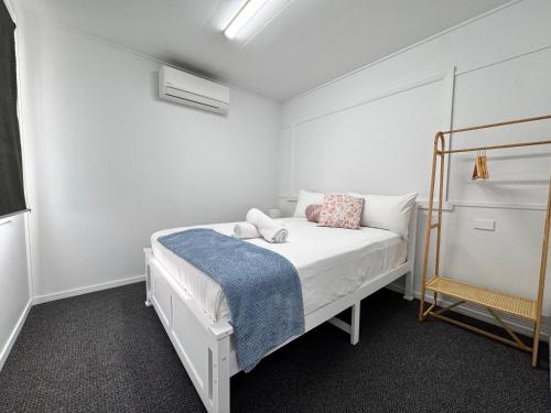 a small bedroom with a bed with a blue blanket at Spacious 4-Bedroom Home in Belgian Gardens in Belgian Gardens