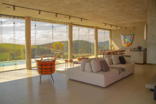 a living room with a white couch and large windows at Windows House in Paty do Alferes