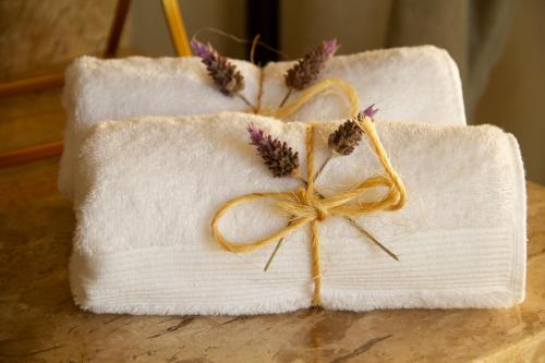 two white towels with flowers on top of a table at Windows House in Paty do Alferes