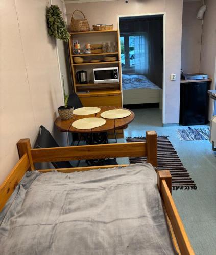 a room with a table and a table and a kitchen at Namiņš in Ragaciems