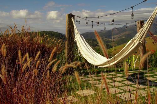 a hammock hanging on a pole in a field at Windows House in Paty do Alferes