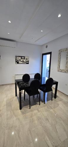 a room with a table and chairs and a wall at Le luxe MENZAH5 in Ariana