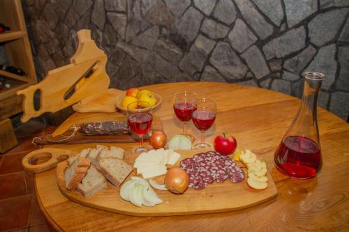 a wooden table with wine glasses and food on it at Zidanica Krošelj in Raka