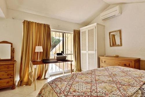 a bedroom with a bed and a desk and a window at Villa Quadradinhos 21Q 4 Bedroooms Private Pool Vale Do Lobo in Vale do Lobo