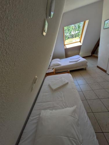 a room with two beds and a window at Auberge de Pra-Loup in Pra-Loup