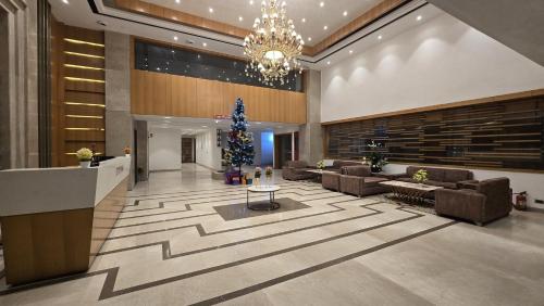 a lobby with couches and a christmas tree in it at Hotel Shemron 