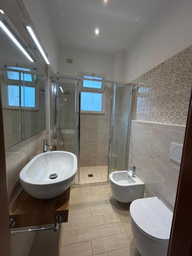 a bathroom with a sink and a toilet and a shower at Hotel De La Ville in Rimini
