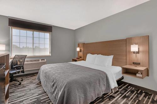 a hotel room with a bed and a desk and a window at Quality Inn Chesterton near Indiana Dunes National Park I-94 in Chesterton
