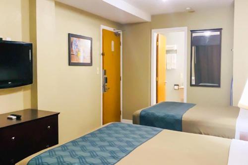 a hotel room with two beds and a tv at Econo Lodge Inn & Suites Old Saybrook - Westbrook in Old Saybrook