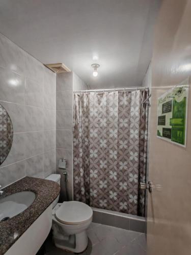 ein Badezimmer mit Dusche, Toilette und Waschbecken in der Unterkunft Mountain Breeze in Baguio City