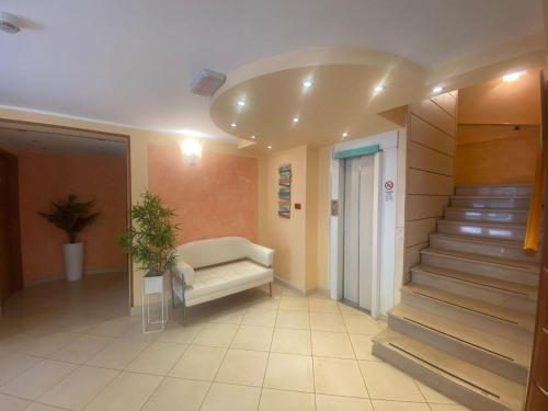 a hospital hallway with a white couch and stairs at Hotel De La Ville in Rimini