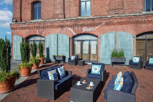a patio with couches and chairs in front of a brick building at The Inn at Henderson's Wharf, an Ascend Collection Hotel in Baltimore