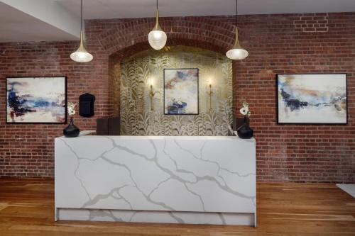 a brick wall with a white counter in a room at The Inn at Henderson's Wharf, an Ascend Collection Hotel in Baltimore
