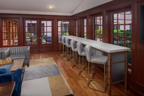 a bar with stools in a room with windows at The Inn at Henderson's Wharf, an Ascend Collection Hotel in Baltimore