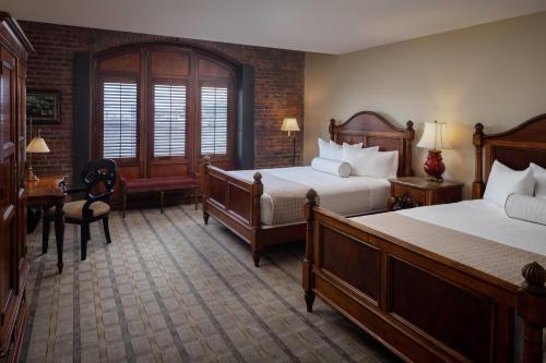 a hotel room with two beds and a desk at The Inn at Henderson's Wharf, an Ascend Collection Hotel in Baltimore
