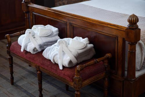 two piles of towels sitting on a bench next to a bed at The Inn at Henderson's Wharf, an Ascend Collection Hotel in Baltimore