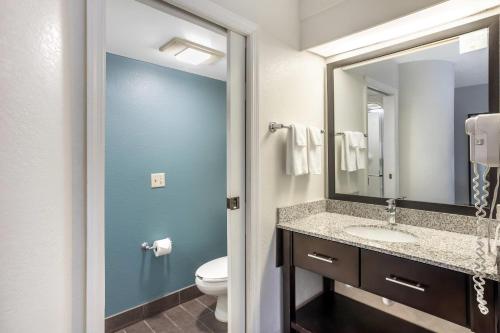 a bathroom with a sink and a toilet and a mirror at Sleep Inn near Penn State - State College, PA in State College